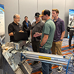 Group Standing over SpoutRunner Equipment