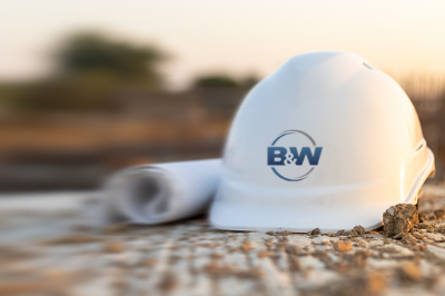 Close up of a hardhat and blueprint roll