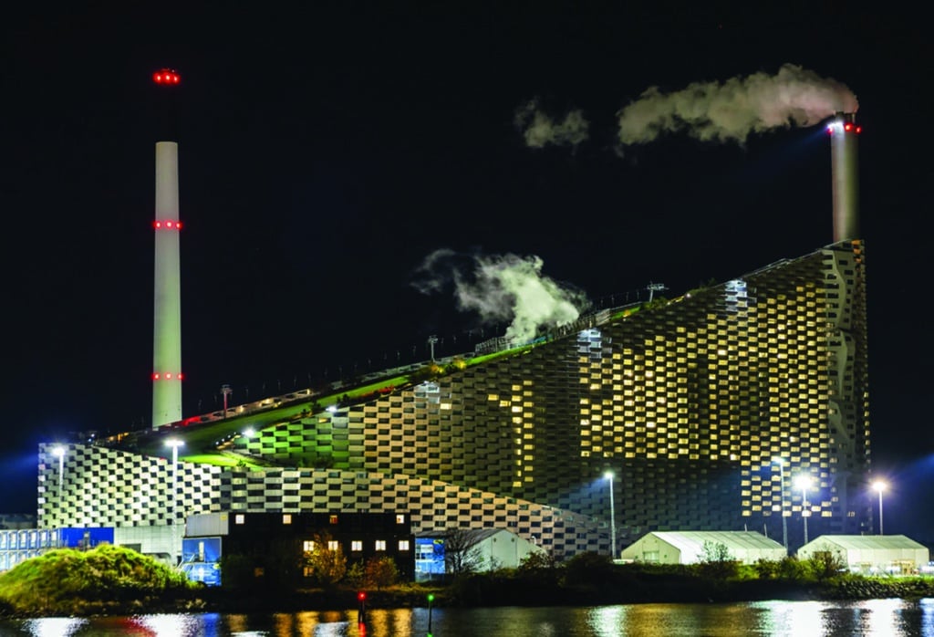 Large waste to energy power plant with ski slope on the roof at night